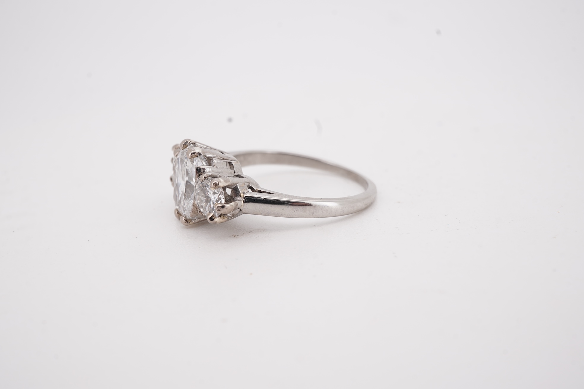 A diamond ring, set with a cushion-shaped diamond weighing 1.50 carats, between shoulders set with brilliant-cut diamonds totalling approximately 0.40 carats, size K, gross weight approximately 4 grams, Condition: centra